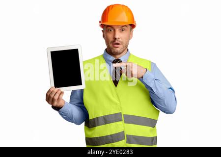 Surprised Worker Man Showing Tablet Screen On White Studio Background Stock Photo