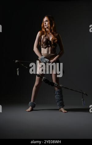 A poised warrior stands confidently in a creative studio during a dramatic shoot Stock Photo