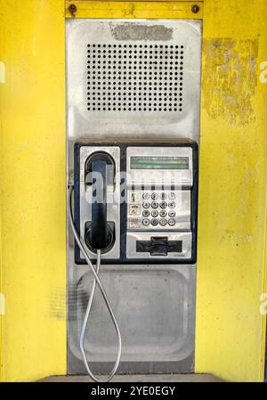 Dial if You Remember: Forgotten Technology Concept of a Wired Headset in a City Phone Booth Stock Photo