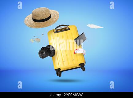 Suitcase, passport, ticket, sunglasses, hat, camera and paper plane in air on blue background. Ready to travel Stock Photo