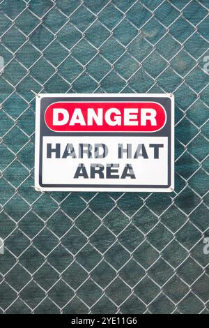 Sign danger hard hat area on a chain link fence, Stock Photo