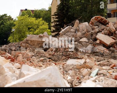 Demolition rubble of a collapsed building. Heap of steel reinforced concrete blocks lying around. Construction site of an architectural project. Stock Photo
