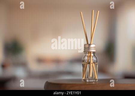 Aromatic air freshener close-up. Aroma sticks in glass bottle on table in room, home comfort concept, high resolution. Stock Photo