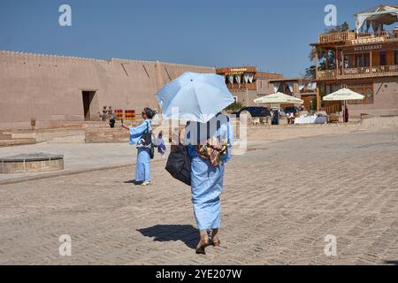 Khiva,Uzbekistan; September,21,2024:two women, both dressed in blue, as they enjoy a walk through the charming streets of Khiva, Uzbekistan. Stock Photo