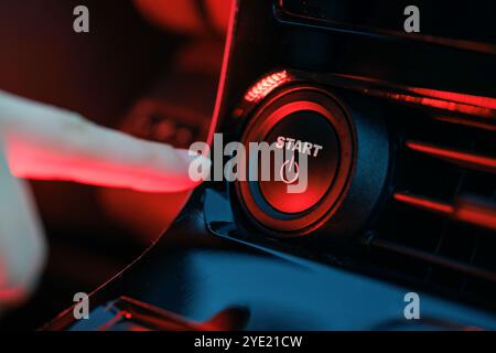 hand pressing start button on car panel, action activation concept, engine start Stock Photo