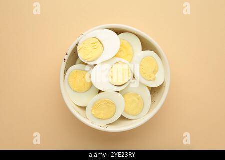 Boiled eggs in a bowl on beige background. Top view Stock Photo