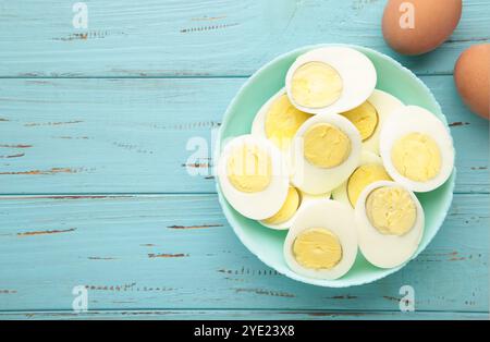 Boiled eggs in a bowl on blue wooden background. Top view Stock Photo