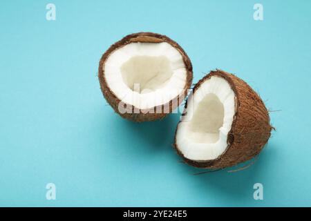 Coconut with half on blue background. Space for text. Top view Stock Photo