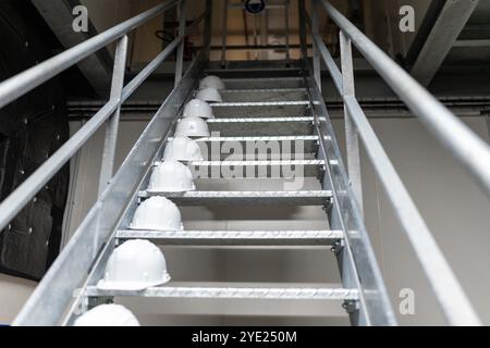 Illustration of construction helmets on a staircase in a factory to protect workers during his visit to the Scaleway company data center site. With the aim of discussing data center implementation issues and conditions for greening these infrastructures, particularly concerning the energy consumption. Indeed, Scaleway has data centers that use 100% energy renewable. The latest DC5 data center uses a system of adiabatic cooling based on the evaporation of water and which avoids the need for air conditioning. October 28, 2024, in Saint-Ouen-l'Aumone (Val-d'oise) near Paris. Photo by Alexis Jumea Stock Photo