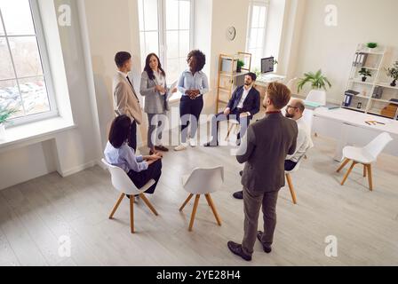 Team and coach talking, active multiracial group of office workers brainstorming discussing business Stock Photo