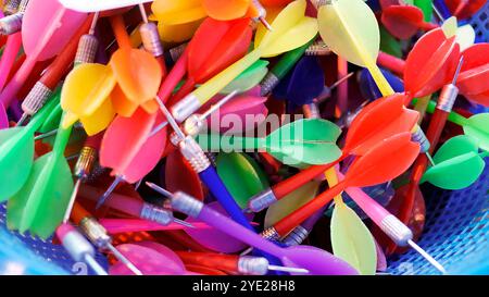 Top view of Colorful used darts in plastic basket contain ready for player in Carnival festival game pop balloons on the wall to win a prize at Thai R Stock Photo