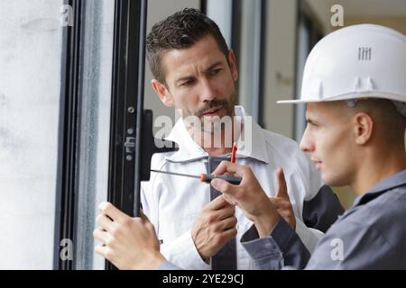 construction worker installing window in house Stock Photo