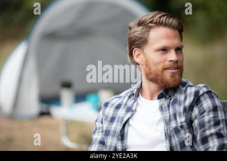 handsome cheerful man camping outdoors Stock Photo