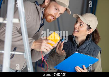 teacher observing students working on electrical circuits Stock Photo