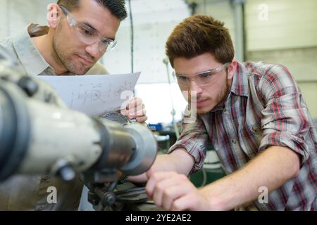 engineers setting up machinery from detailed plans Stock Photo
