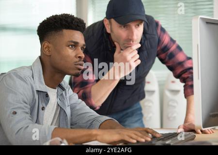 two serious men looking at computer screen Stock Photo