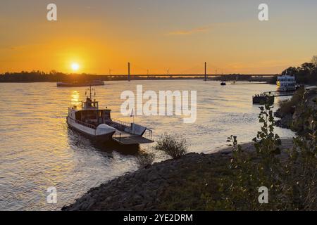 Sunset over the river Rhine Lower Rhine, left in the foreground small passenger ferry two-wheel ferry Rees, in the background bridge Rhine bridge two- Stock Photo
