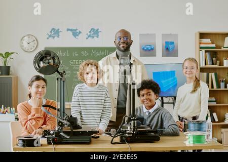 Multi-ethnic students learning 3D modeling with devices and technology in classroom setting. Teacher demonstrating a process while students actively engaging and participating in activities Stock Photo