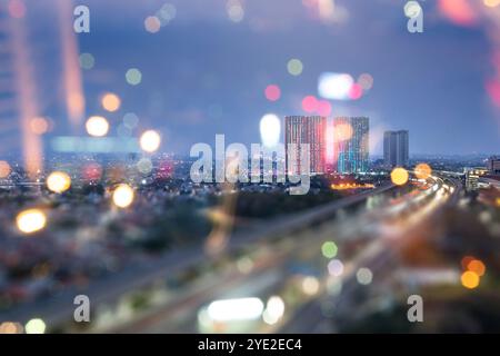 View of street traffic with building and modern city skyline with colorful bokeh light background. Jakarta, Indonesia. Cityscapes background Stock Photo