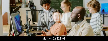 Teacher and students participating in engaging classroom discussion focusing on technology and innovation Stock Photo