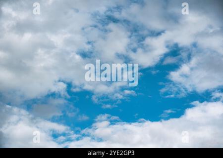 Vibrant blue sky filled with fluffy white clouds in sunny day, Creating a serene and peaceful atmosphere Stock Photo