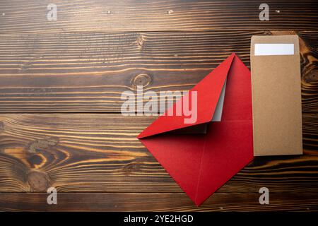 Top view of stack of two envelope and postcard on wooden background. The envelopes are of different variation size and colors. Mockup, blank template, Stock Photo