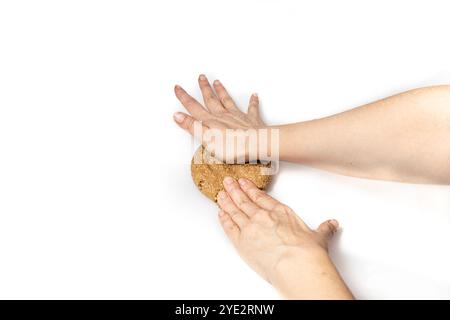 Hand holding homemade oatmeal cookie dough on a white background with space for text Stock Photo