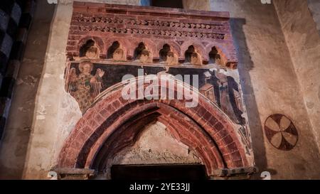 The vibrant frescoes adorn the walls of the ancient church in Alba, depicting scenes from medieval times with intricate details Stock Photo