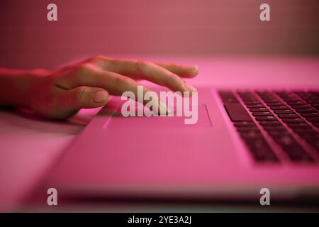 Typing on Laptop with Pink Ambient Lighting Stock Photo