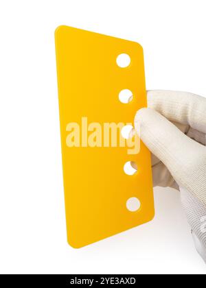 Yellow plastic spatula for smoothing stickers in hand on white background Stock Photo