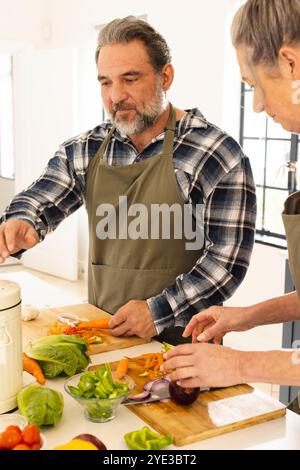 Preparing fresh vegetables, mature couple cooking together in bright kitchen, at home Stock Photo
