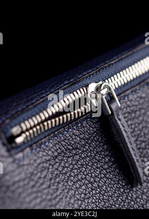Part of a blue leather bag on a black background. Leather goods. Stock Photo