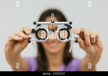 Female optometrist holding trial frame for pediatric eye exam Stock Photo