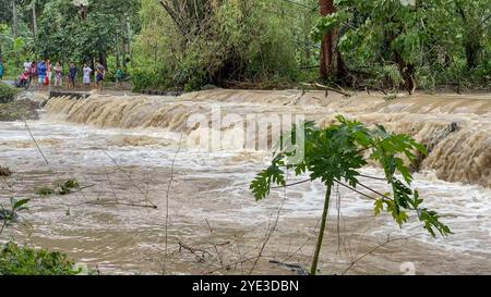 Laguna, Luzon Island, Philippines. Oct 25,2024: Heavy rains turned a small river into a powerful floodwater torrent cutting off the road. Severe Tropical Cyclone Trami (Kristine) aftermath in Philippine archipelago, one of the world's most climate vulnerable regions as the Southeast Asia's country is struck by multiple natural disasters a year. Millions of Filipinos suffered torrential rainfall, floods, strong winds, damages, landslides, electricity/internet outages, evacuation. The deadliest storm killed 145 peoples/37 missing. Many areas remain isolated. Credit: Kevin Izorce/Alamy Live News Stock Photo