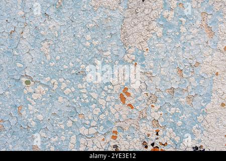 An old wall background with a blue and white peeling paint. Pastel colored creative background. Stock Photo