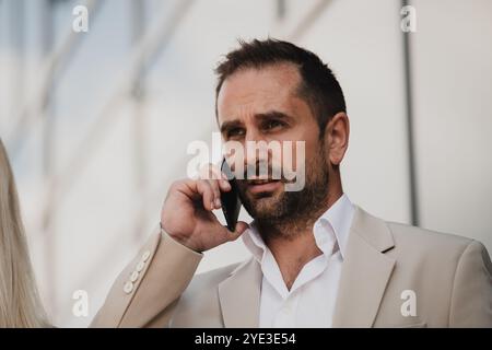 A businessman using his smartphone outdoors, showcasing the seamless integration of technology and mobility in modern professional life. Stock Photo