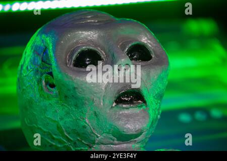 February 23, 2024. Belarus. Minsk. Educational open event about alien worlds.The alien's face is highlighted in the green color of the laboratory. The Stock Photo