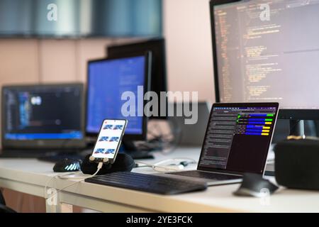 Computer screens running programming code in empty software developing agency office and computers parsing data algorithms in background. Neural Stock Photo