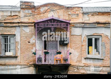 Street View.Traditional old crumbling building in the old town of Tbilisi with a decorated purple balcony. Georgia Stock Photo