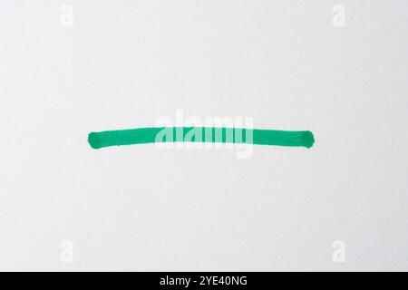 green stroke hand drawn with felt tip or fiber tip pen on white paper surface background, close-up of marker stripe or line handwritten sketch Stock Photo