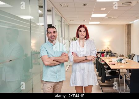 Two business workers smiling happy standing with arms crossed gesture at the office. Stock Photo