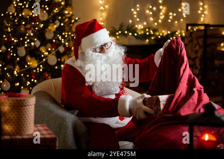 Santa Claus packing gifts in box Stock Photo - Alamy