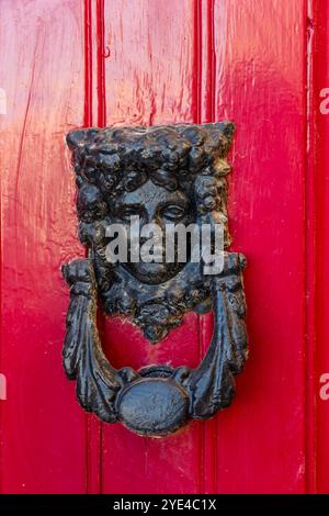 Vintage Door Knocker on Classic Red Panel Door Stock Photo