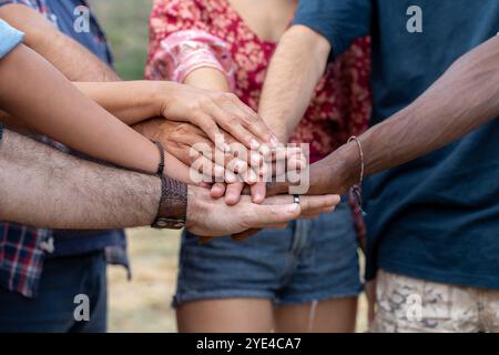 Close up of multiethnic hands joined in circle showing unity, teamwork and inclusion. Authentic moment of diverse community members symbolizing suppor Stock Photo