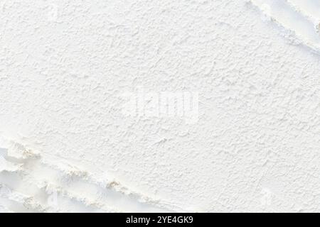 Close-up of abstract uneven and rough surface made of white molding paste. High resolution full frame textured background, copy space. Stock Photo