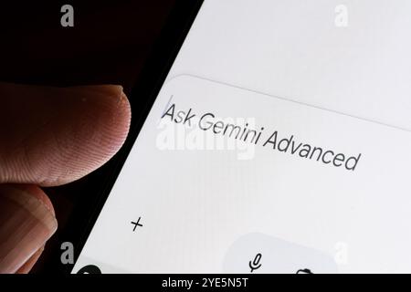 Close-up of smartphone screen showing "Ask Gemini Advanced" text entry, highlighting advanced GEMINI AI assistant prompt in chat interface. Stafford, Stock Photo
