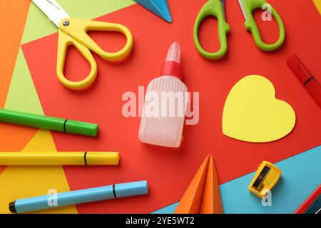 Flat lay composition with glue, scissors and other stationery on color background Stock Photo