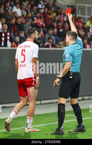 Regensburg, Germany. 29th Oct, 2024. Soccer: DFB Cup, Jahn Regensburg - SpVgg Greuther Fürth, 2nd round, Jahnstadion Regensburg. Referee Tom Bauer (r) shows Jahn Regensburg's Rasim Bulic the red card. Credit: Daniel Löb/dpa - IMPORTANT NOTE: In accordance with the regulations of the DFL German Football League and the DFB German Football Association, it is prohibited to utilize or have utilized photographs taken in the stadium and/or of the match in the form of sequential images and/or video-like photo series./dpa/Alamy Live News Stock Photo