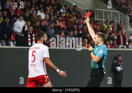 Regensburg, Germany. 29th Oct, 2024. Soccer: DFB Cup, Jahn Regensburg - SpVgg Greuther Fürth, 2nd round, Jahnstadion Regensburg. Referee Tom Bauer (r) shows Jahn Regensburg's Rasim Bulic the red card. Credit: Daniel Löb/dpa - IMPORTANT NOTE: In accordance with the regulations of the DFL German Football League and the DFB German Football Association, it is prohibited to utilize or have utilized photographs taken in the stadium and/or of the match in the form of sequential images and/or video-like photo series./dpa/Alamy Live News Stock Photo