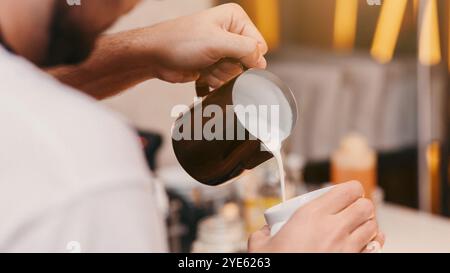 Unrecognizable Barista Making Cappuccino Adding Milk In Cup In Cafeteria Stock Photo